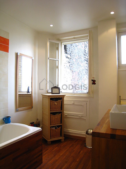 Belle salle de bain très claire avec fenêtres et du parquet au sol