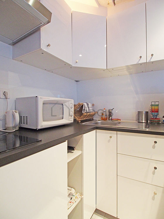 Kitchen equipped with hob, refrigerator, crockery, stool