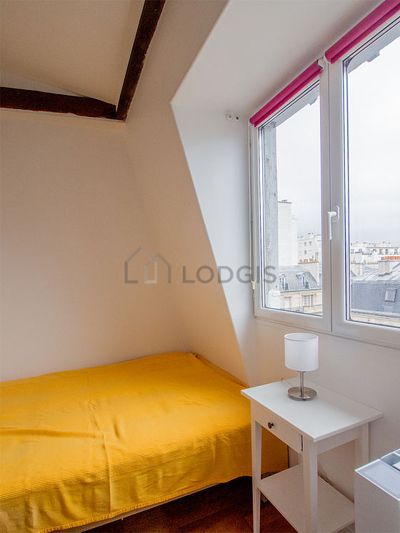 Chambre avec fenêtres donnant sur rue