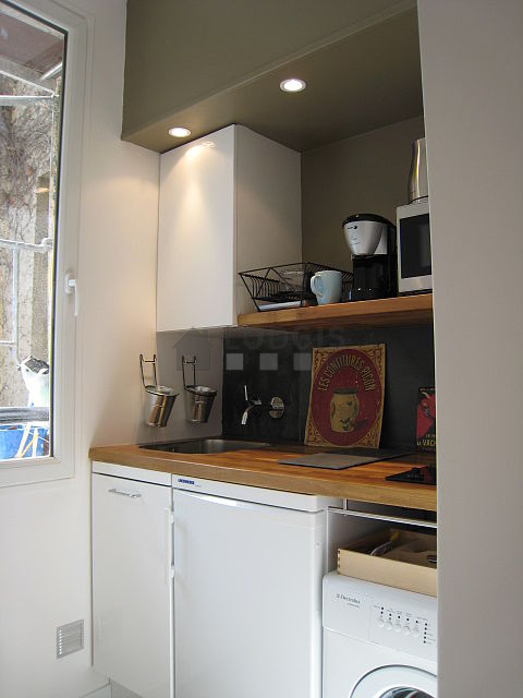 Kitchen equipped with hob, refrigerator, crockery
