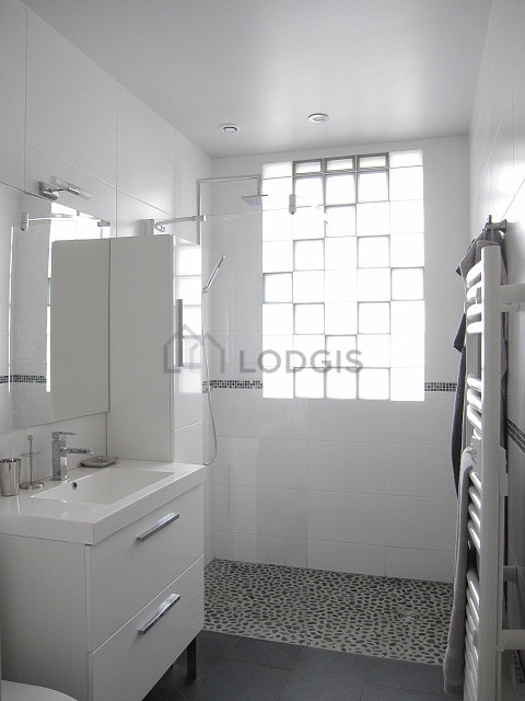 Agréable salle de bain claire avec fenêtres et du carrelage au sol