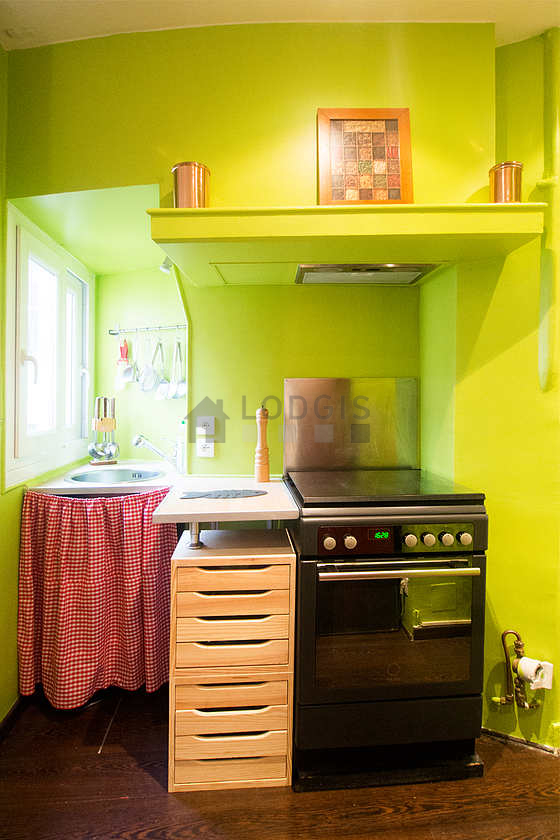 Cuisine équipée de plaques de cuisson, réfrigerateur, hotte, vaisselle