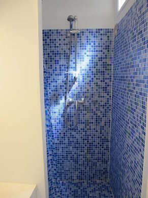 Salle de bain équipée de douche séparée, radiateur sèche-serviettes
