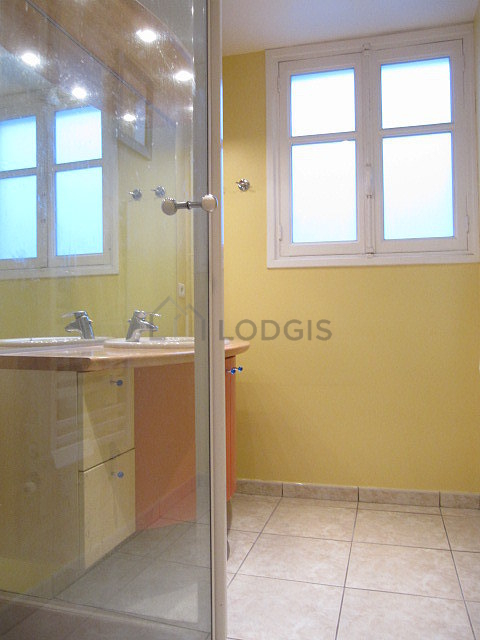 Belle salle de bain claire avec fenêtres double vitrage et du carrelage au sol