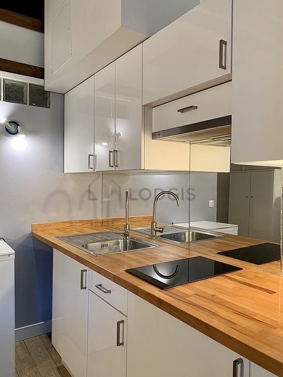 Cuisine équipée de plaques de cuisson, réfrigerateur, hotte, vaisselle