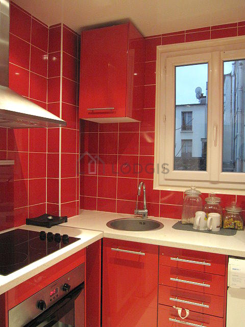 Cuisine équipée de plaques de cuisson, réfrigerateur, hotte, vaisselle
