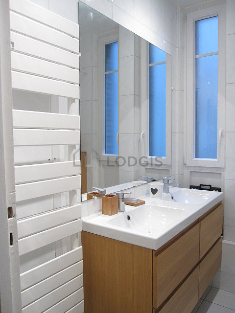 Belle salle de bain claire avec fenêtres double vitrage et du carrelage au sol