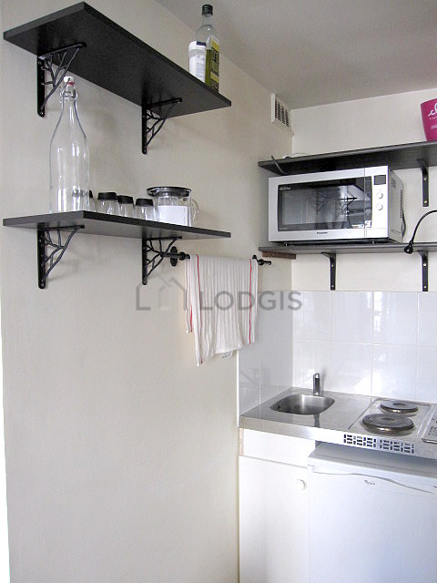 Kitchen equipped with hob, refrigerator, freezer, crockery