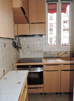 Kitchen equipped with hob, refrigerator, extractor hood, crockery