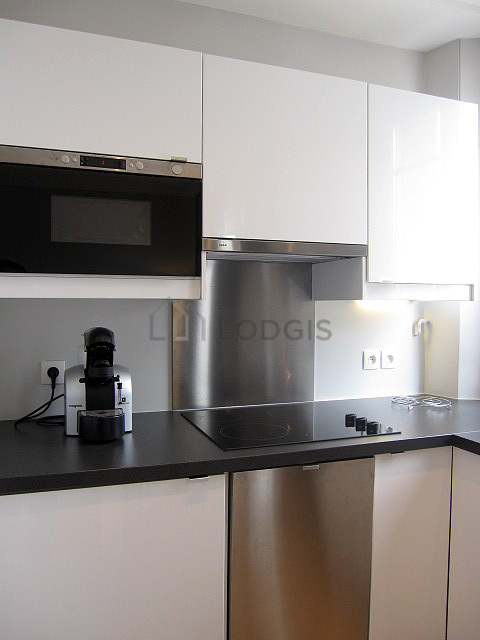 Kitchen equipped with washing machine, refrigerator, extractor hood, crockery