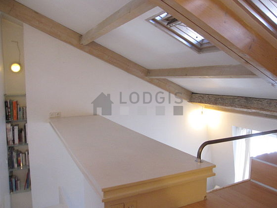 Mezzanine sous belle hauteur de plafond avec du parquet au sol