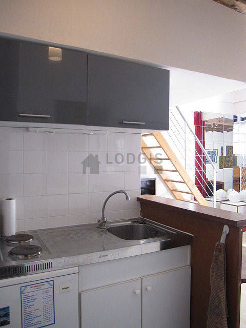 Kitchen equipped with hob, refrigerator, freezer, crockery