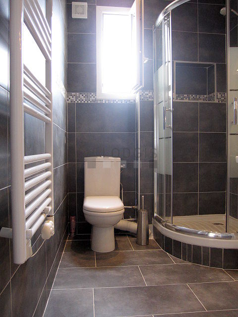 Belle salle de bain claire avec fenêtres double vitrage et du carrelage au sol