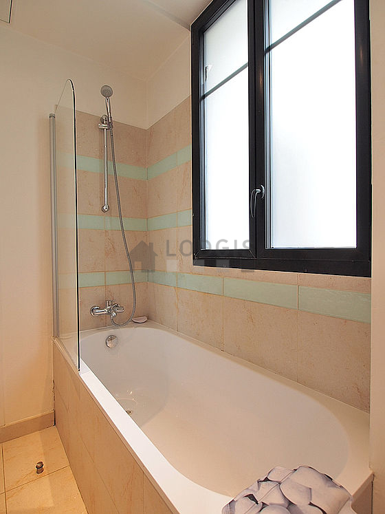 Belle salle de bain claire avec fenêtres double vitrage et du carrelage au sol