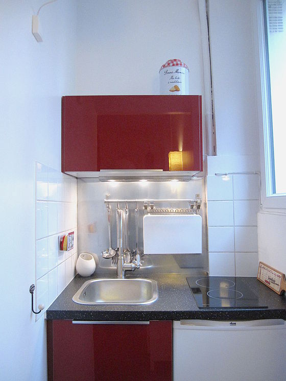Kitchen equipped with hob, refrigerator, freezer, crockery