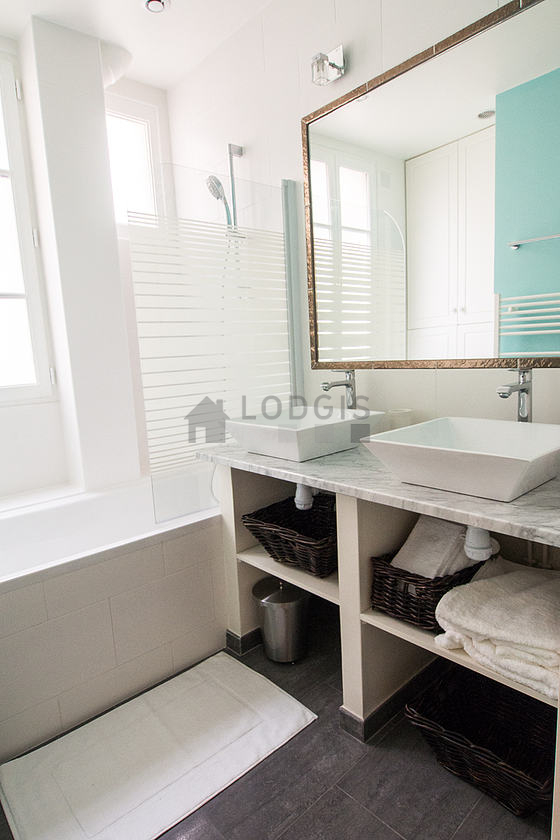 Belle salle de bain claire avec fenêtres double vitrage et du carrelage au sol