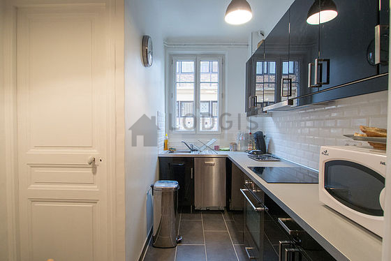 Cuisine équipée de plaques de cuisson, réfrigerateur, hotte, vaisselle