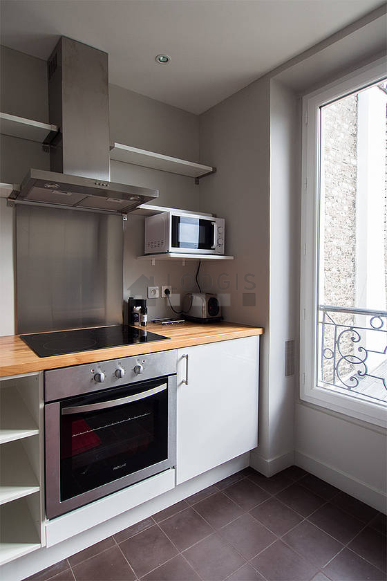 Cuisine équipée de lave vaisselle, plaques de cuisson, réfrigerateur, hotte