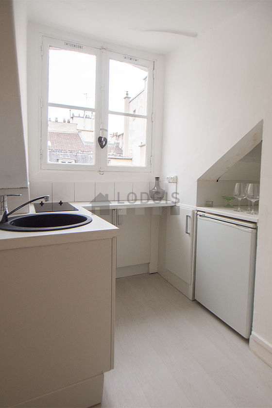 Kitchen equipped with hob, refrigerator, extractor hood, crockery