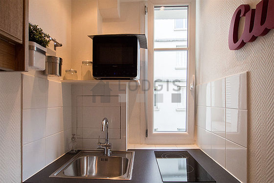 Kitchen equipped with hob, refrigerator, crockery, stool