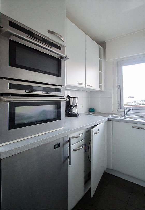 Kitchen equipped with washing machine, dryer, refrigerator, extractor hood