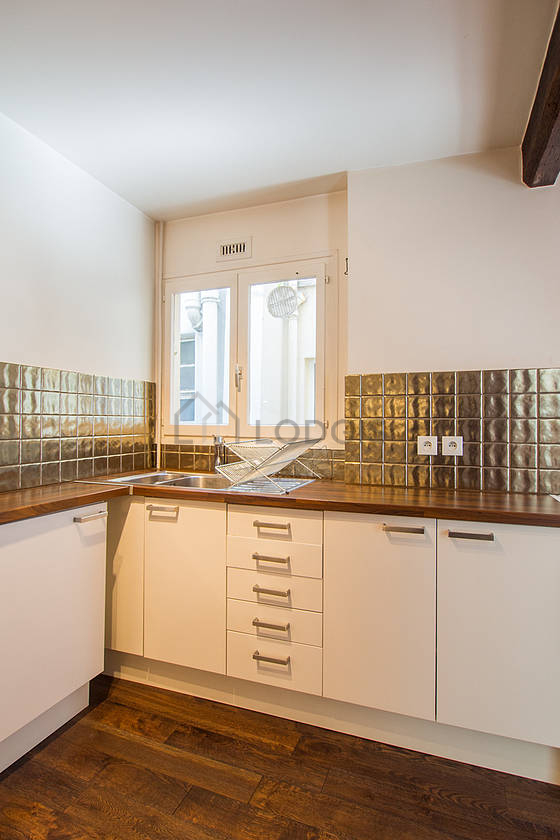 Kitchen equipped with washing machine, refrigerator, extractor hood, crockery