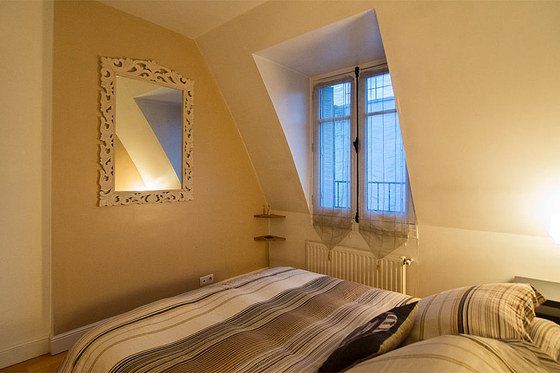Bright bedroom equipped with storage space, bedside table