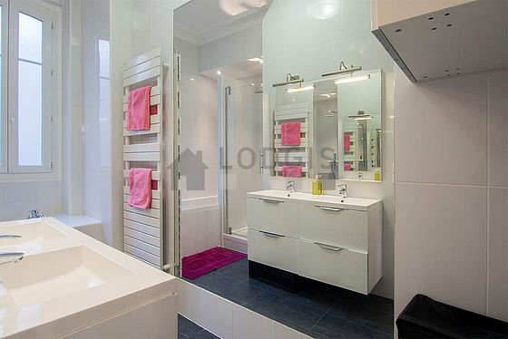 Belle salle de bain claire avec fenêtres et du carrelage au sol