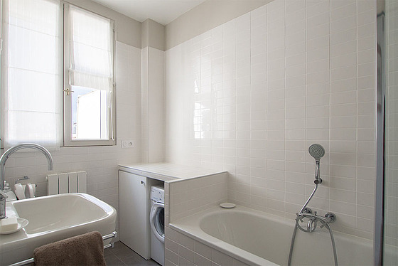 Belle salle de bain claire avec fenêtres double vitrage et du carrelage au sol