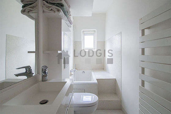 Belle salle de bain claire avec fenêtres et du carrelageau sol