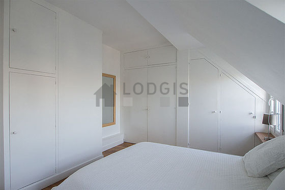Bright bedroom equipped with 1 armchair(s), bedside table