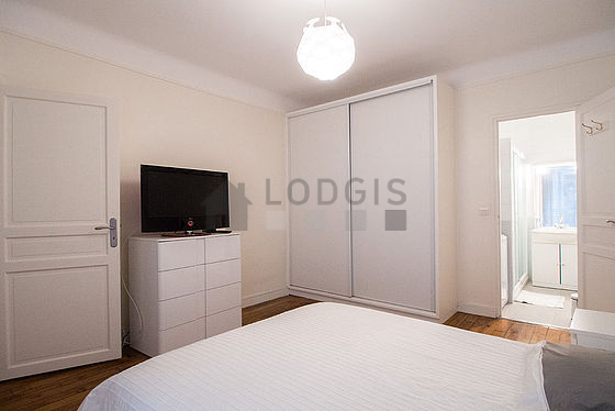 Bright bedroom equipped with tv, bedside table