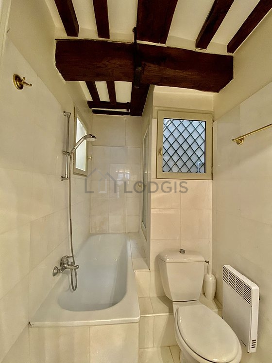 Belle salle de bain avec fenêtres et du carrelage au sol