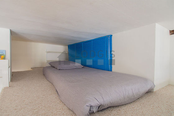 Mezzanine sous belle hauteur de plafond avec de la moquette au sol
