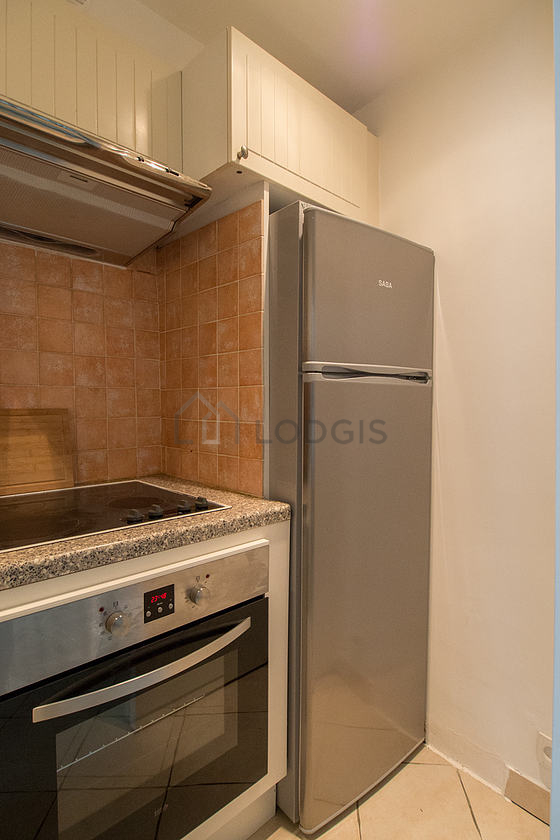 Cuisine équipée de plaques de cuisson, réfrigerateur, hotte, vaisselle