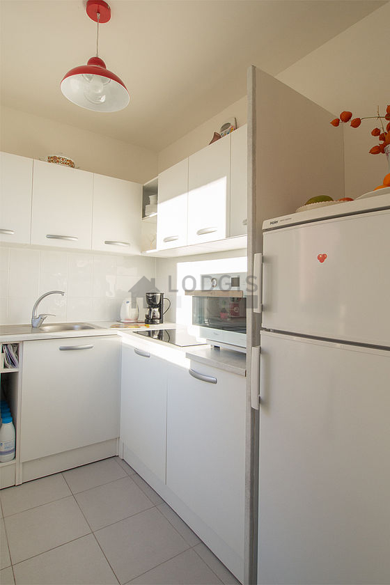 Kitchen equipped with dishwasher, hob, refrigerator, crockery
