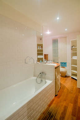 Agréable salle de bain claire avec fenêtres double vitrage et du parquetau sol