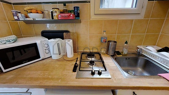 Kitchen equipped with hob, refrigerator, freezer, crockery