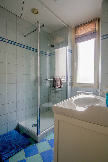 Agréable salle de bain claire avec fenêtres et du carrelageau sol
