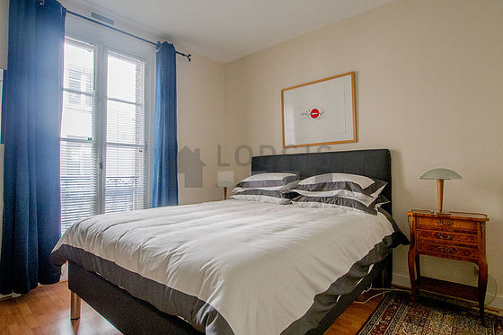 Very bright bedroom equipped with tv, bedside table