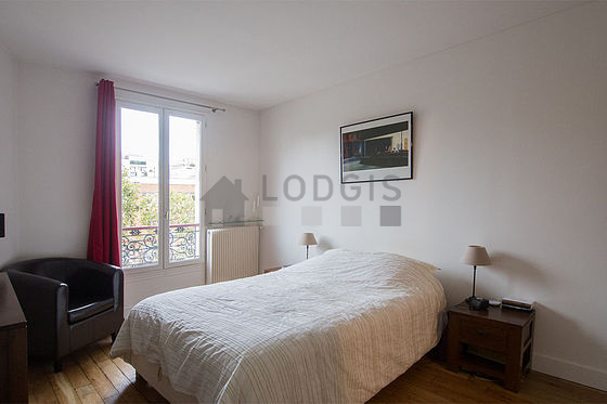 Bright bedroom equipped with 1 armchair(s), bedside table