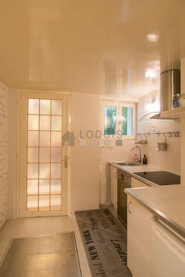 Kitchen equipped with extractor hood, crockery, stool