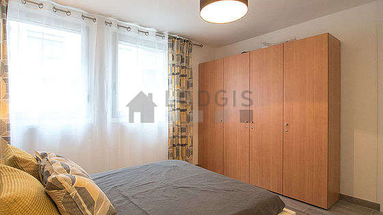 Bright bedroom equipped with wardrobe, bedside table