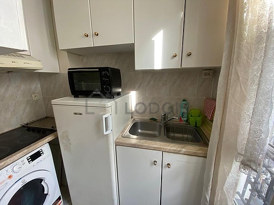 Kitchen equipped with washing machine, refrigerator, extractor hood, crockery