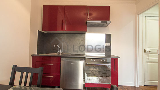 Kitchen equipped with hob, refrigerator, extractor hood, crockery