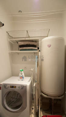 Beautiful laundry room with tilefloor and equipped with washing machine