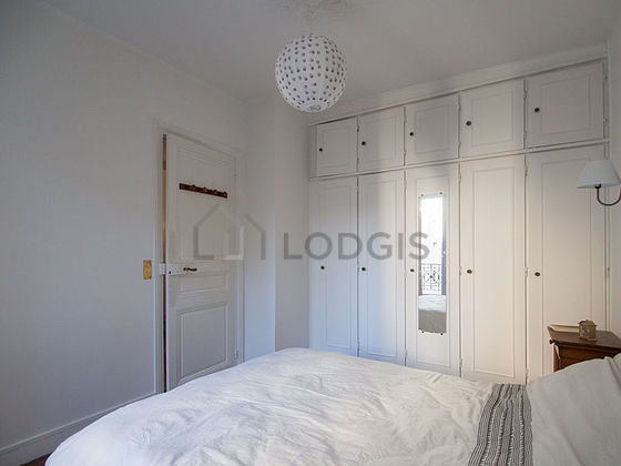 Bright bedroom equipped with wardrobe, cupboard, bedside table