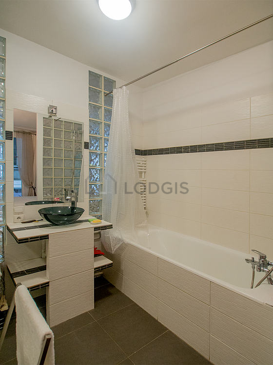 Agréable salle de bain claire avec du carrelage au sol