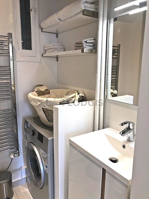 Bathroom equipped with washing machine, separate shower, towel drying radiator