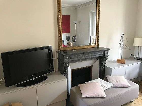 Quiet living room furnished with tv, 1 armchair(s)